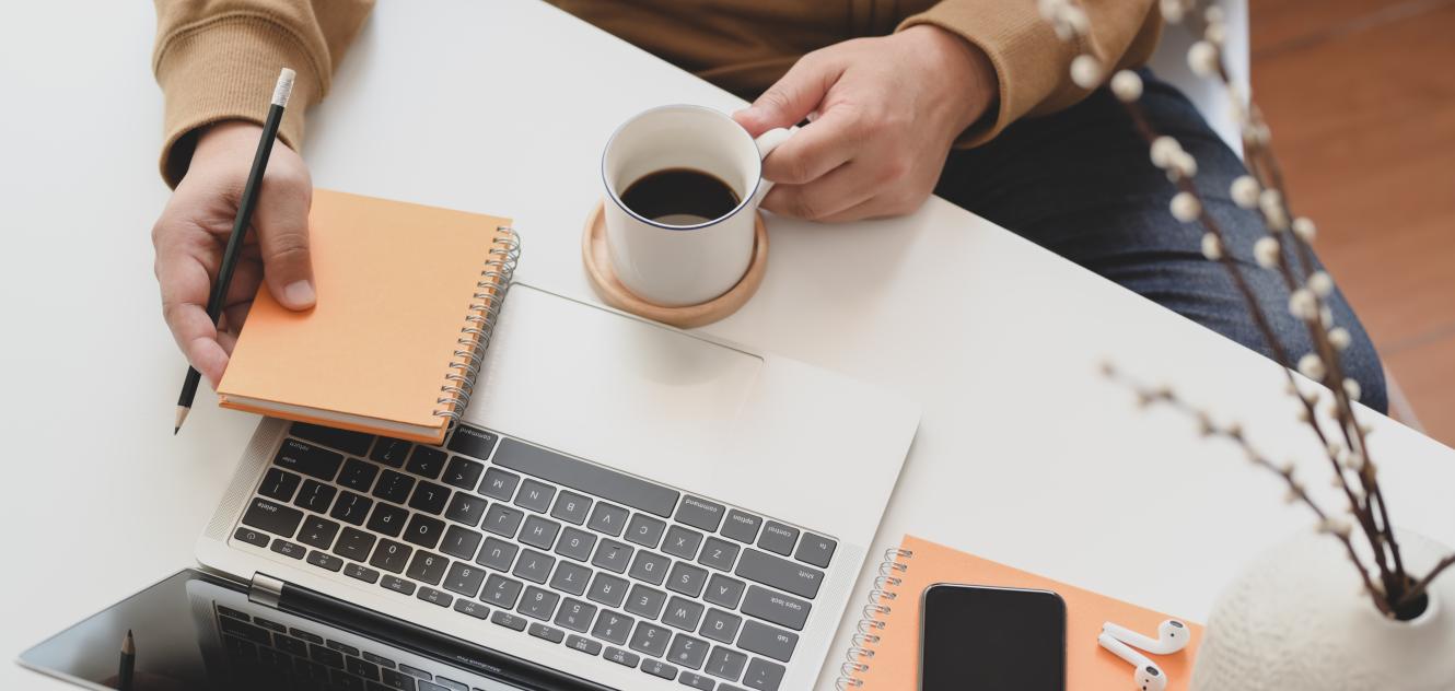 person holding white ceramic mug beside macbook pro 3787300